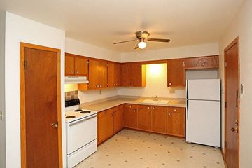 Manitowoc apartment for rent - a kitchen with white appliances and wooden cabinets