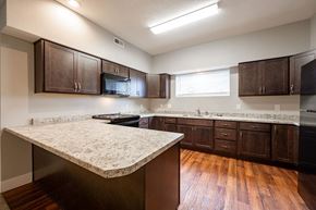 Rushville apartment for rent - A kitchen with brown cabinets and a granite countertop.