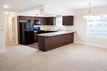 Knightstown apartment for rent - A kitchen with brown cabinets and a black refrigerator.