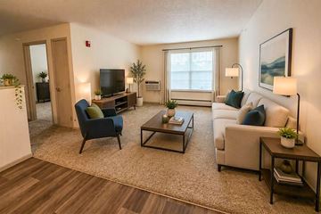 Creston apartment for rent - A living room with a blue chair, a white couch, and a coffee table.