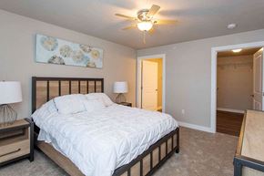 Sister Bay apartment for rent - A bedroom with a bed, two lamps, and a ceiling fan.
