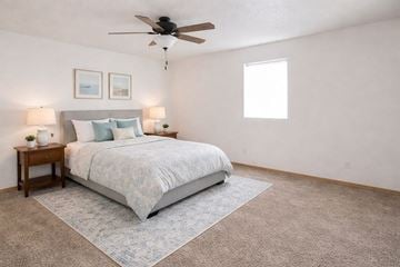 Knoxville apartment for rent - A bedroom with a large bed and a ceiling fan.
