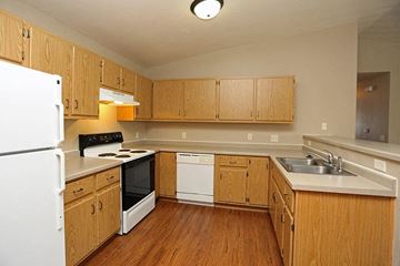 Rhinelander apartment for rent - a kitchen with wooden cabinets and a stove and a refrigerator