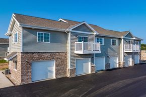 Sturgeon Bay apartment for rent - a blue house with blue garage doors and a balcony