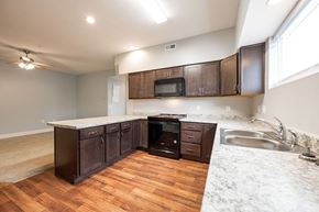 Rushville apartment for rent - A kitchen with dark wood cabinets and a white marble countertop.