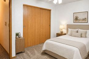 Fond Du Lac apartment for rent - A bedroom with a large bed and a wooden door.