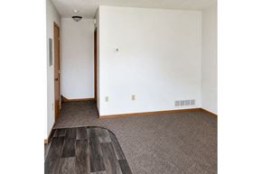 Sleepy Eye townhouse for rent - A room with a white wall and a brown door.