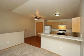 Rhinelander apartment for rent - an empty living room with a kitchen and a ceiling fan