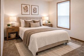 Albert Lea townhouse for rent - A bedroom with a large bed and two lamps on either side of the bed.
