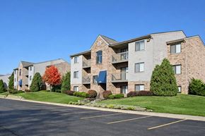 Riverside apartment for rent - Apartment building with a parking lot in front.