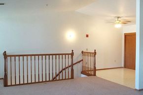 Neenah apartment for rent - a living room with a staircase and a ceiling fan
