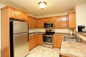 Grafton apartment for rent - a kitchen with stainless steel appliances and wooden cabinets
