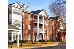 Sumter apartment for rent - A large brick building with a sign in front of it.