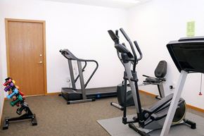 Hutchinson apartment for rent - A home gym with a treadmill, stationary bike, and weights.