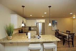 Sheboygan apartment for rent - A kitchen with a granite countertop and a dining table with chairs.