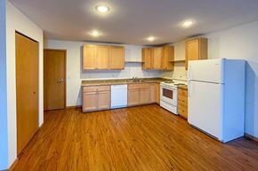 Viroqua apartment for rent - A kitchen with wooden floors and white appliances.