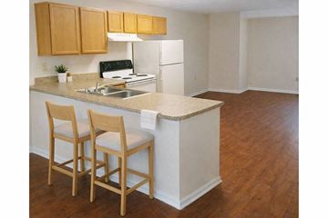 Nicholasville apartment for rent - A kitchen with wooden chairs and a white counter.