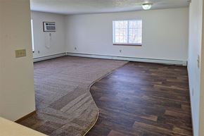 Iowa Falls apartment for rent - A room with a window and a wooden floor.