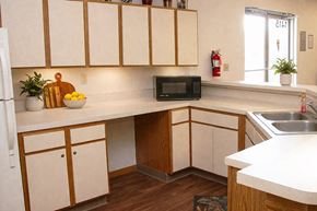 Hutchinson apartment for rent - A kitchen with white cabinets and a black microwave.