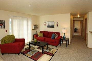 Neenah apartment for rent - a living room with a red couch and a table