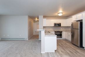 Waupaca apartment for rent - A kitchen with a refrigerator, microwave, and oven.