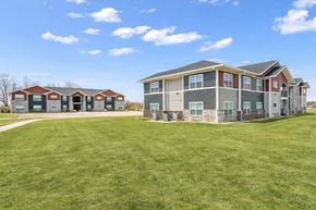 Rushville apartment for rent - A large grassy field in front of a two story apartment building.