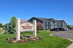 Newton apartment for rent - A sign for Sudance Newton Apartments stands in front of a building.