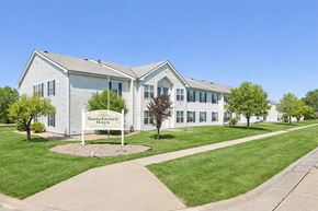 Hays apartment for rent - A white building with a sign that says Sundance Hays in front of it.