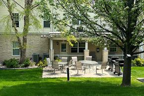 South Milwaukee apartment for rent - A patio with chairs and a table is in front of a building.