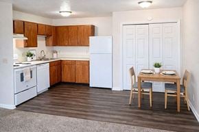 Henderson apartment for rent - A kitchen with a table and chairs in front of a white refrigerator.