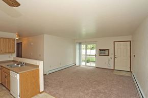 Fond Du Lac apartment for rent - an empty living room with a kitchen and a door