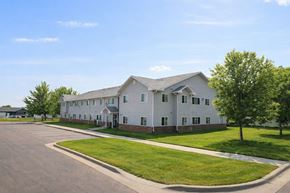 Mitchell apartment for rent - A large white building with a parking lot in front.