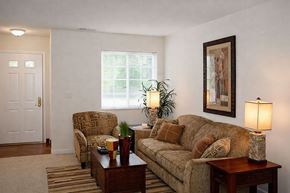 Kalamazoo apartment for rent - A living room with a couch, chair, and lamp.