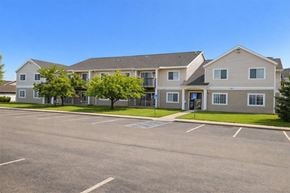 Mason City apartment for rent - A large building with a parking lot in front of it.