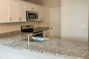 Beaver Dam apartment for rent - A kitchen with granite countertops and white cabinets.