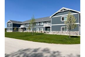 Sister Bay apartment for rent - A large grey building with a white tree in front.