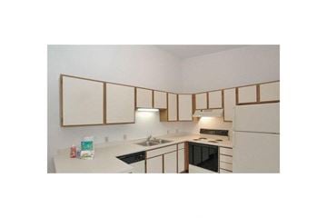 Howard apartment for rent - a kitchen with white cabinets and a stove and a sink
