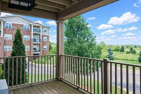 Milwaukee apartment for rent - A balcony with a view of a road and trees.