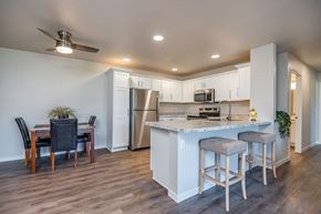 Shawano apartment for rent - A kitchen with a bar stool and a dining table.
