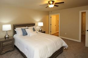 Sheboygan apartment for rent - A bedroom with a bed, two lamps, and a ceiling fan.