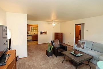 Wisconsin Rapids apartment for rent - A living room with a grey couch and a black chair.