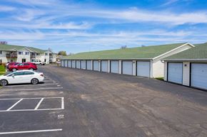 Columbus apartment for rent - a parking lot with garages and cars in front of a building