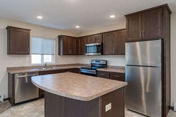 Windom apartment for rent - A kitchen with brown cabinets and a stainless steel refrigerator.