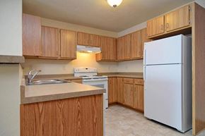 Little Chute apartment for rent - A kitchen with wooden cabinets and a white refrigerator.