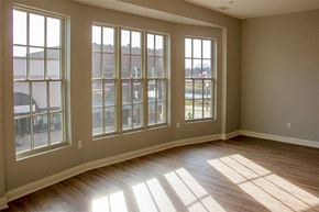 Charles City apartment for rent - an empty living room with large windows and wooden floors