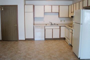Sheboygan Falls apartment for rent - A kitchen with white appliances and wooden cabinets.