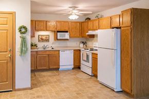 Milwaukee apartment for rent - A kitchen with wooden cabinets and white appliances.
