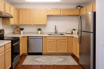 Sumter apartment for rent - A kitchen with wooden cabinets and a stainless steel refrigerator.