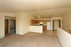 Oshkosh apartment for rent - an empty living room and kitchen with a refrigerator