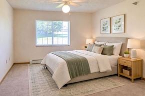 Mason City apartment for rent - A bedroom with a bed, nightstand, and window.